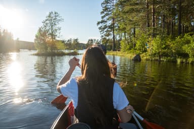 A beautiful day of canoeing in the Malingsbo-Kloten Nature Reserve with lush green nature in the background.