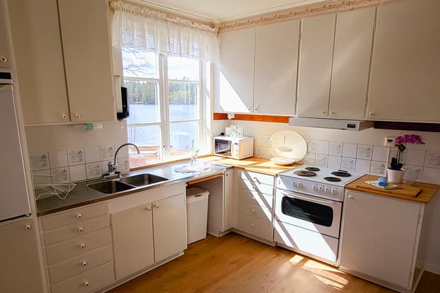 En mer detaljerad vy av köket i kanotistlägenheten på River Lodge. Köket är välutrustat och har utsikt över sjön.