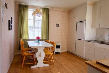 La salle à manger dans l'appartement du canoéiste à River Lodge. La salle à manger est confortable avec des meubles en bois traditionnels et une vue sur la forêt à l'extérieur.