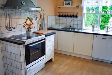 Rincón de la cocina en la cabaña en la naturaleza equipado con estufa y lavadora.