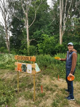 A person standing with a disc golf disc in his hand at the beginning of the Kloten disc golf course in Malingsbo-Kloten nature reserve.