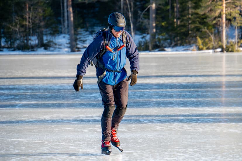 Ein Mann läuft auf einem gefrorenen See in der schwedischen Wildnis Schlittschuh.