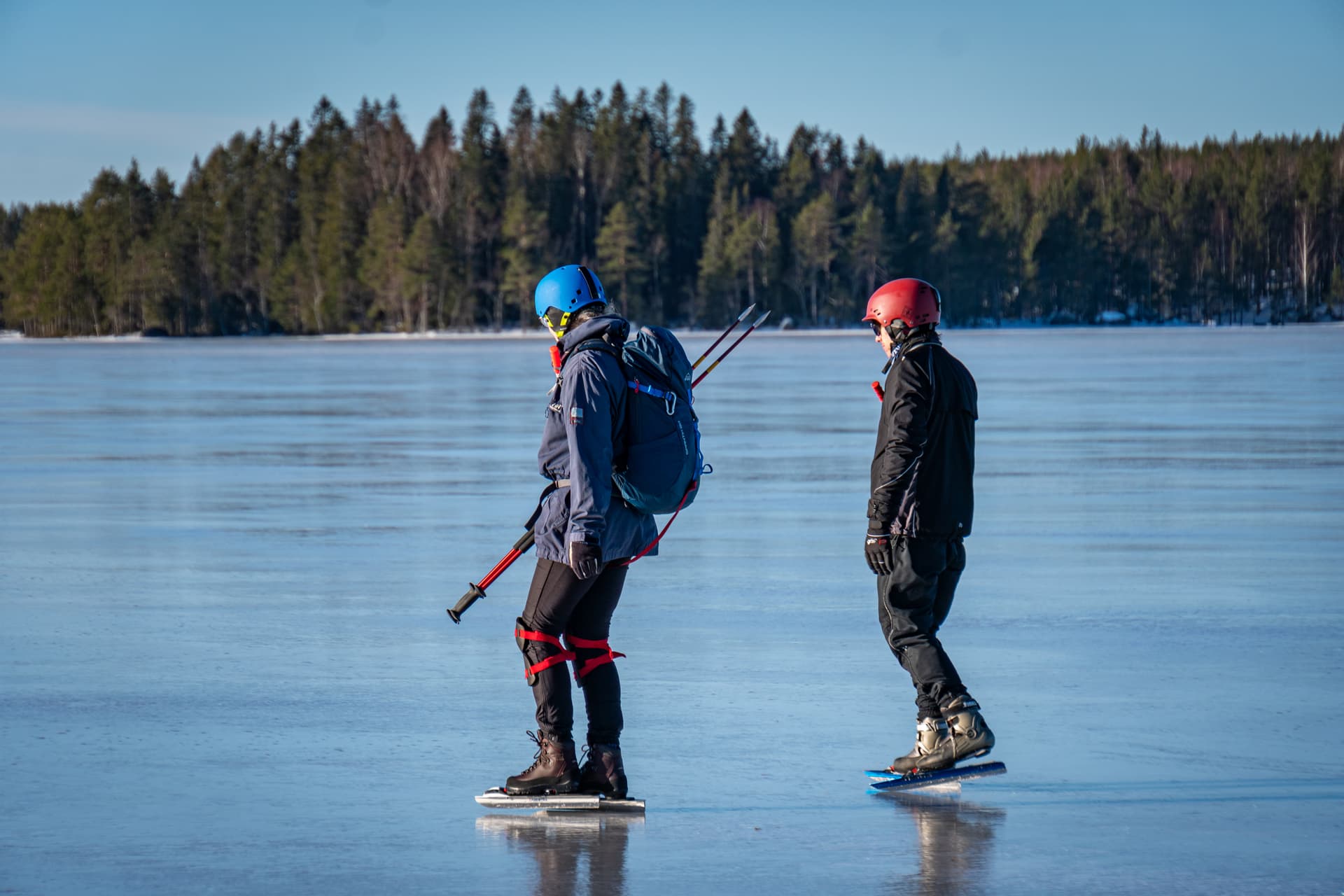 Ein Eisläuferduo aus der Nähe während einer geführten Eislauf-Tour mit blauem Himmel und Eis im Hintergrund.