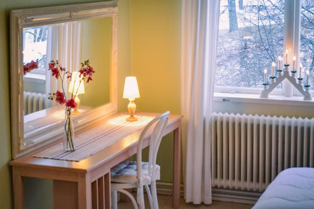 Skrivbord med spegel och vildmarken precis utanför fönstret.