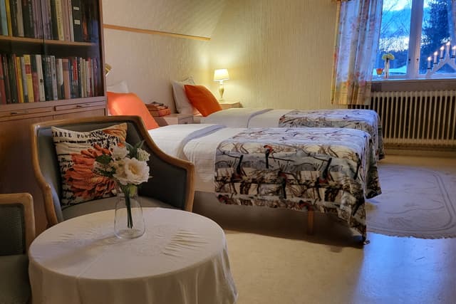Stolar och bokhylla i Bäverrummet på Wilderness Lodge i Sverige.