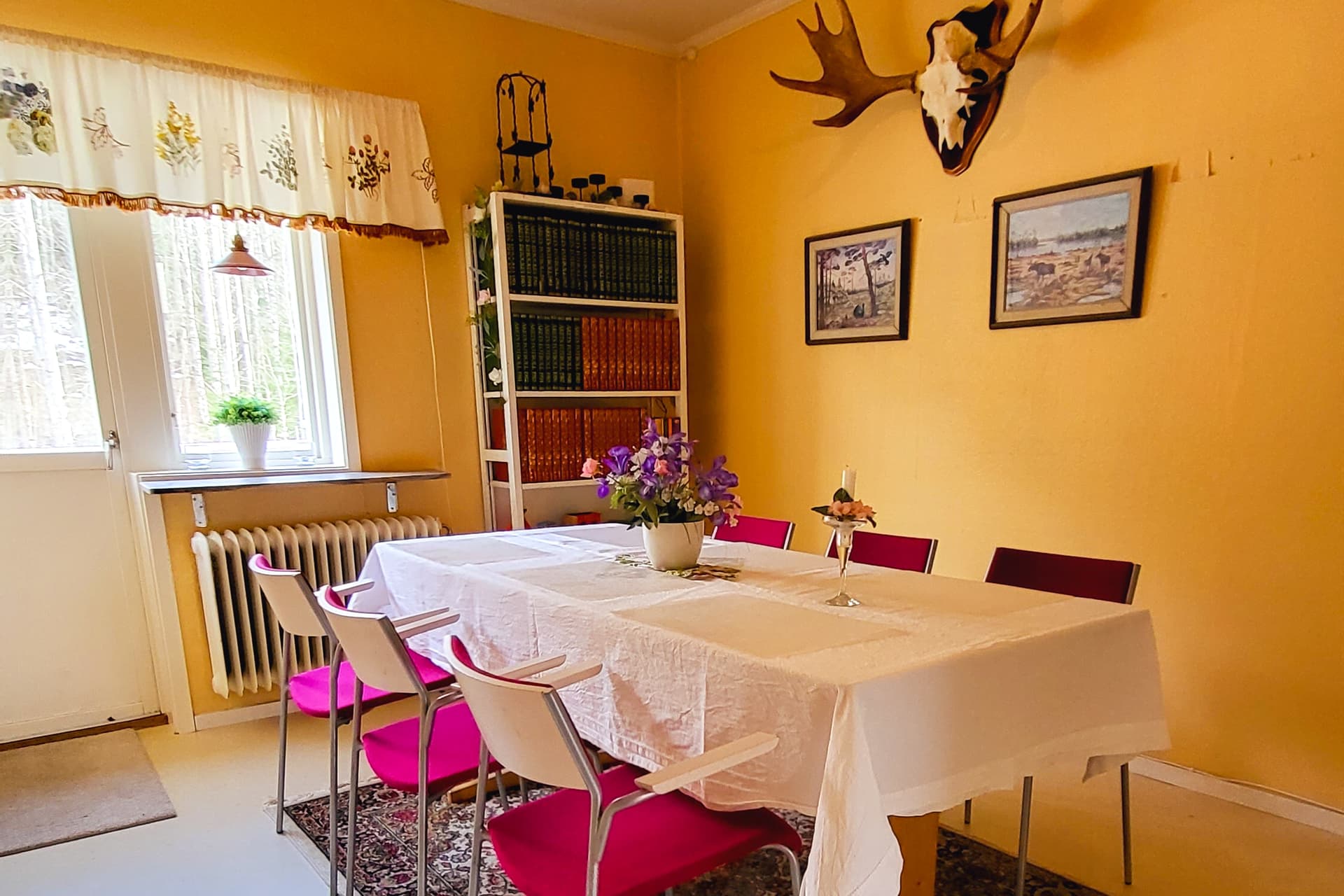 Dining table with chairs in the kitchen at the wilderness lodge. Moose antlers on the wall.