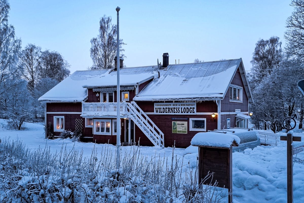 Experimenta la belleza encantadora de un tradicional Wilderness Lodge sueco en invierno. Sumérgete en un paisaje invernal nevado rodeado de paisajes pintorescos y alojamientos acogedores.