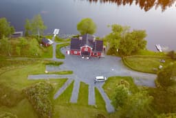 A bird's-eye view of the river lodge with sauna, swimming area, deck, and large veranda.