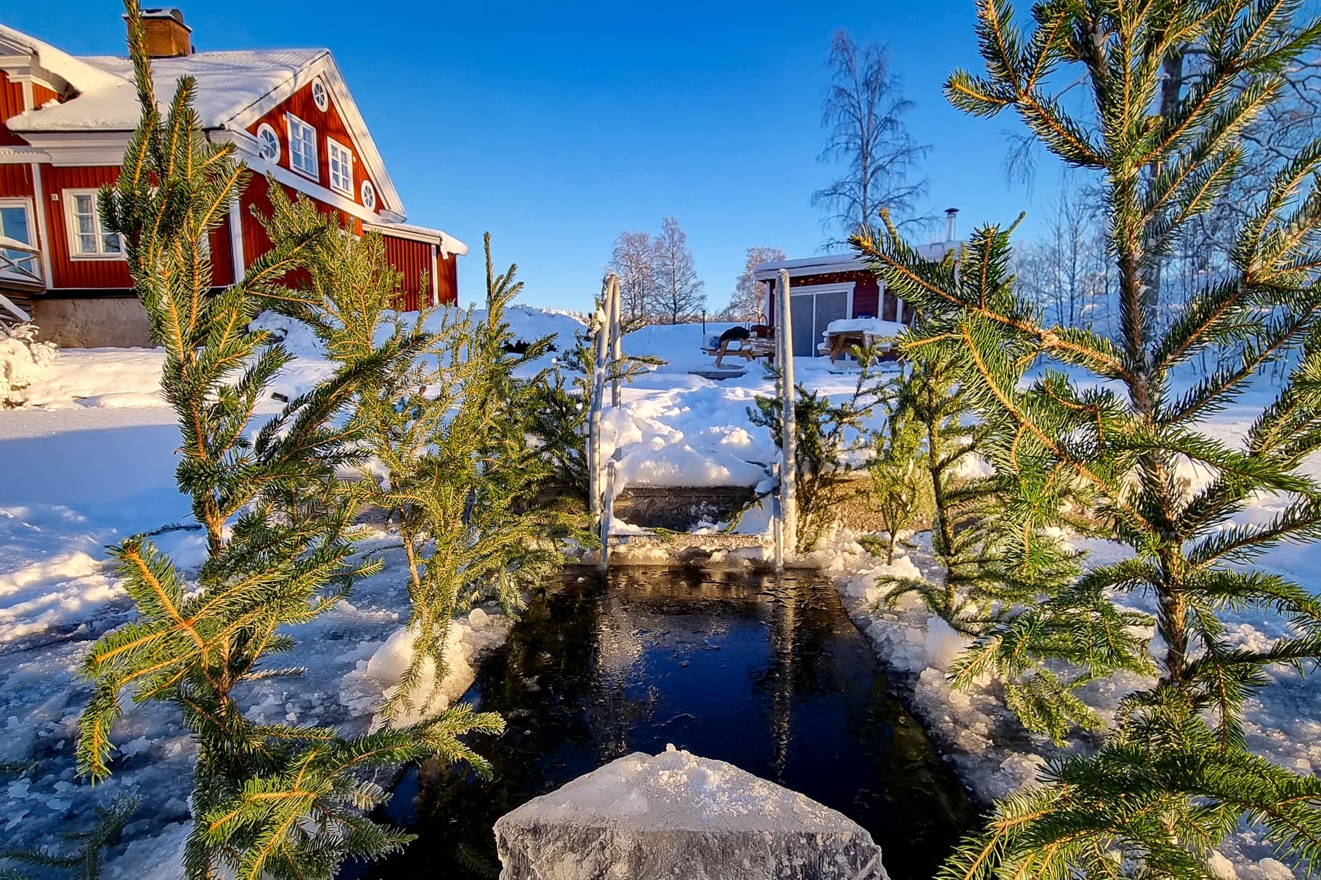 A hole in the ice in front of the sauna at River Lodge. The sauna is warm and cozy on a cold winter day.