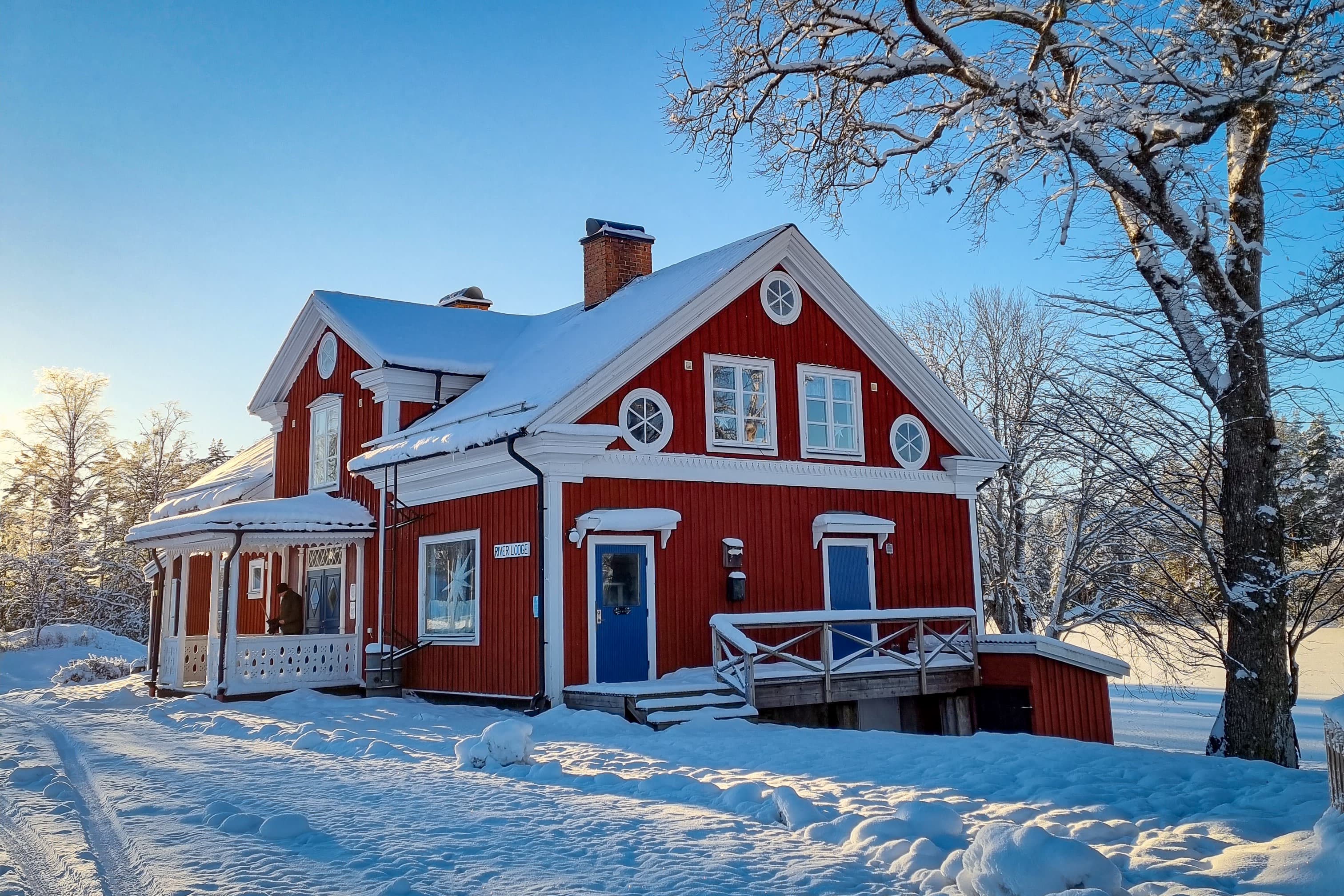 Fresh snow on the ground in front of the River Lodge on a clear winter day.