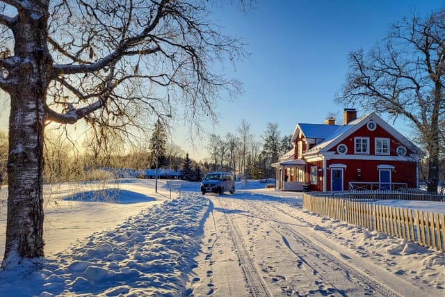 En snötäckt väg som leder till River Lodge mitt i den svenska vintern.